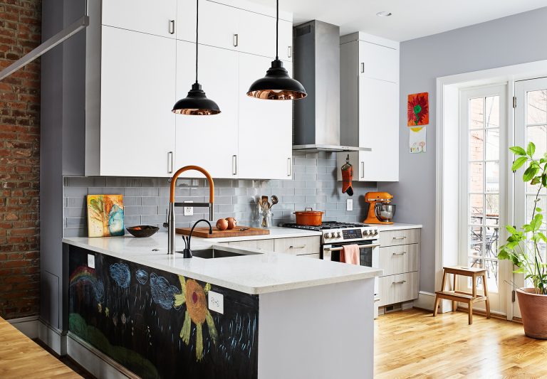 bright dc kitchen with wood floors and glass doors peninsula with chalkboard on back side open to dining room with exposed brick wall