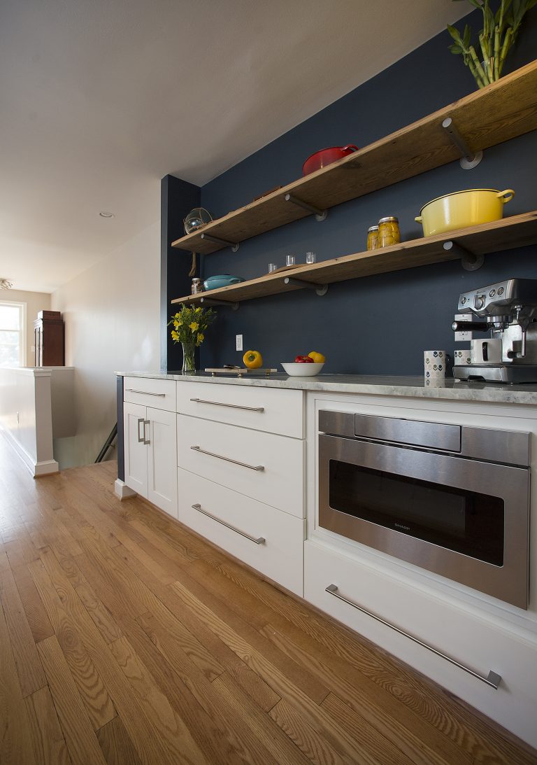 kitchen with navy walls white cabinetry open shelving stainless steel appliances