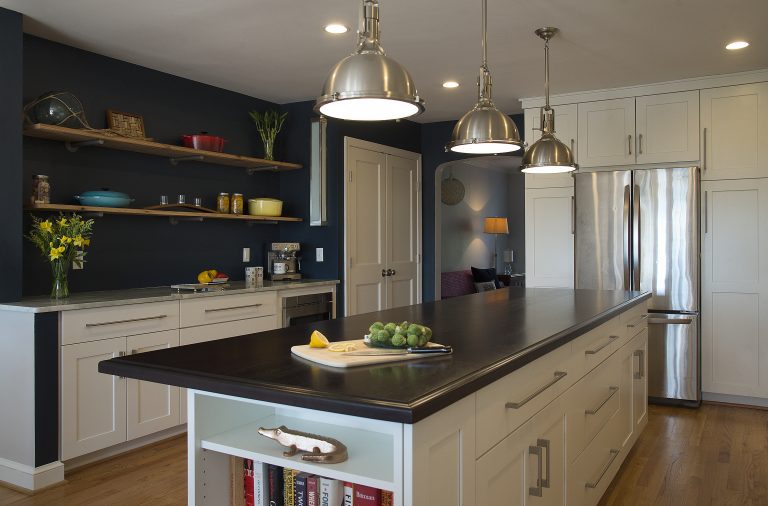 kitchen island with black countertops and open side storage pendant lighting