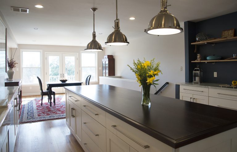 kitchen island with black countertops and open side storage pendant lighting