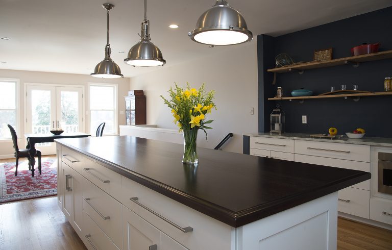 kitchen island with black countertops and open side storage pendant lighting