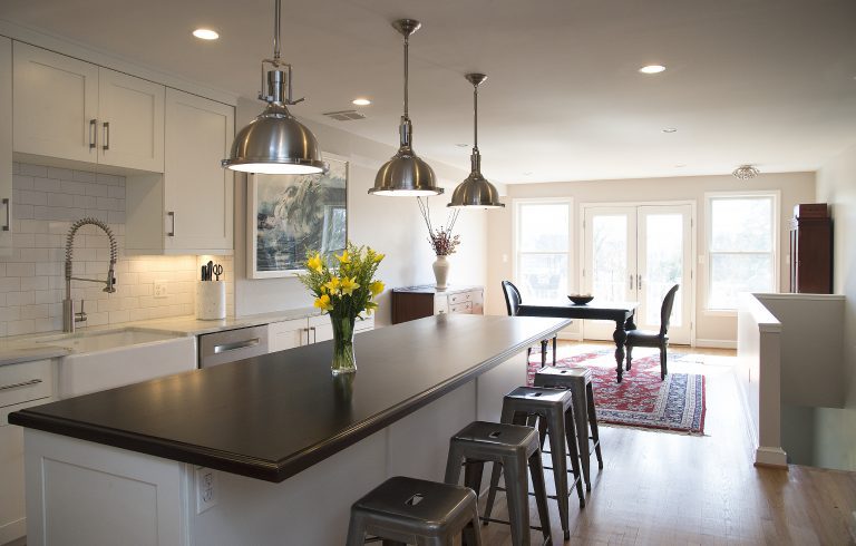 kitchen island with seating and black countertops and open side storage pendant lighting