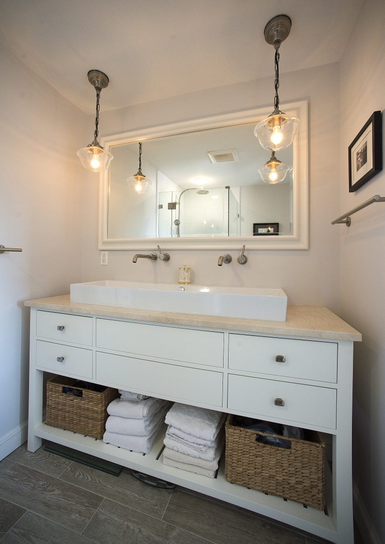 bathroom vanity white cabinetry drawer and shelving built in storage double sink wall mount faucets pendant lighting