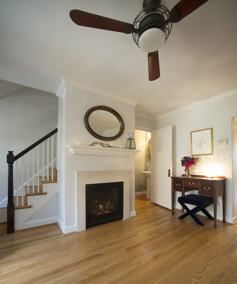traditional style entry area with wood floors fireplace and staircase neutral color palette