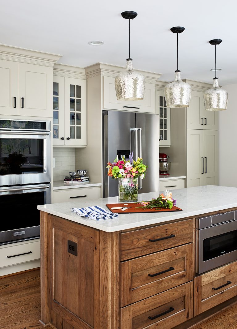 wood kitchen island, subway tiles on the kitchen backsplash with the kitchen island is topped with a slab of white marble