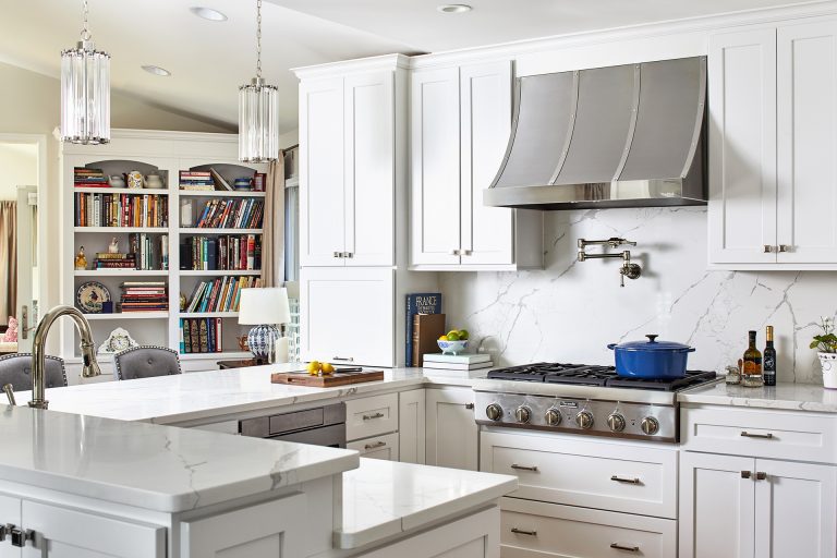 case kitchen design with white marble countertops, white marble backsplash with tall white cabinets with pull handles