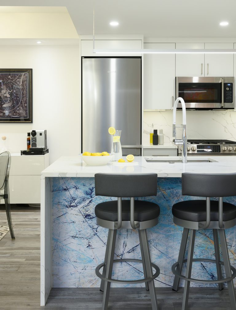 marble countertop blue kitchen island facing three chairs