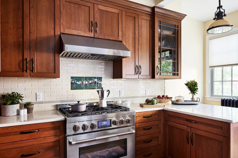 case wood kitchen cabinets, backsplash subway tiles with an inlay tree design