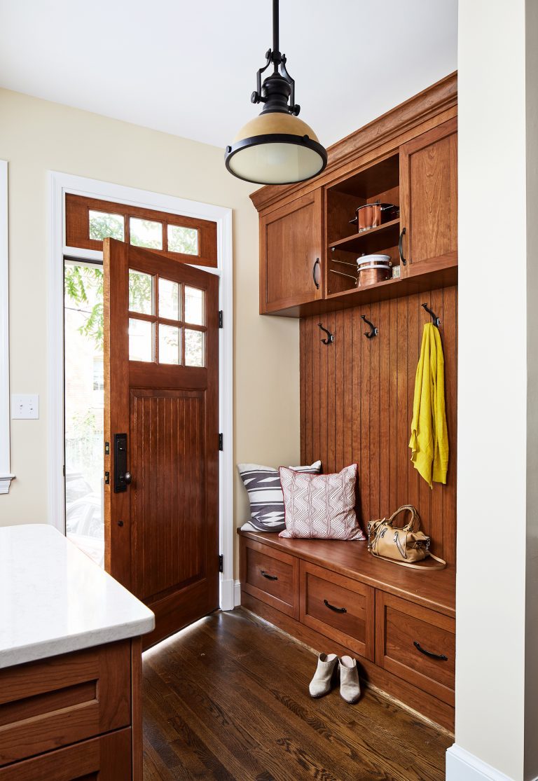 wood mudroom lockers bench and coat rack with a couple of storage drawers and wood hard floors