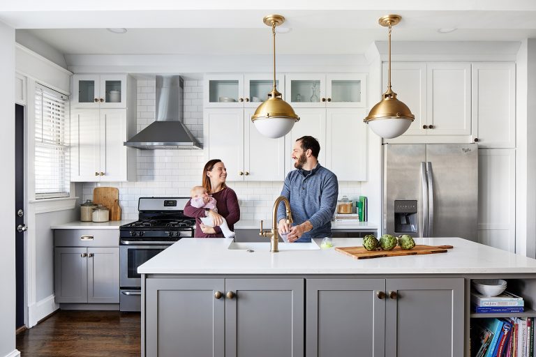 white and grey kitchen with gold hardware and lighting fresh white countertops and subway backsplash, white cabinets with glass doors